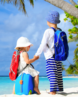 Two young travelers holding hands on the beach.