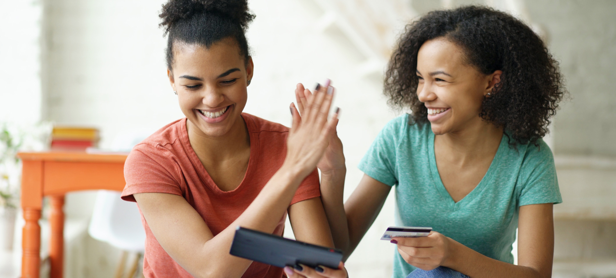 Teen girls using their debit card and mobile app.