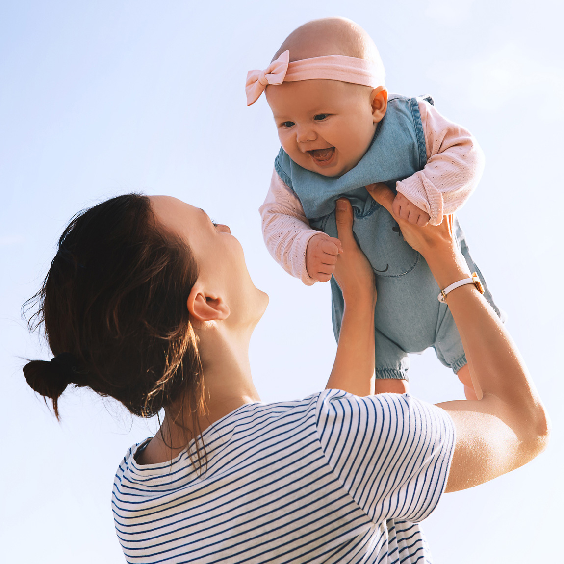 Mom lifting a happy baby