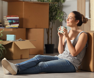 Young woman taking a break while moving into her apartment.