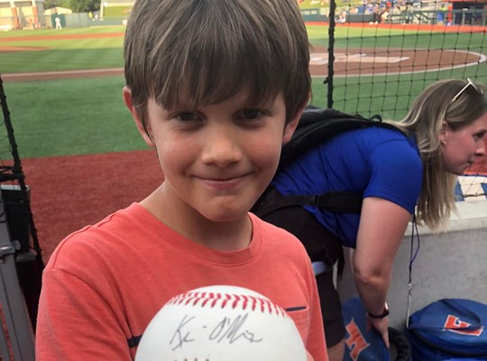 boy holding a signed baseball