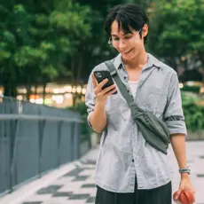 man holding a phone on a bridge