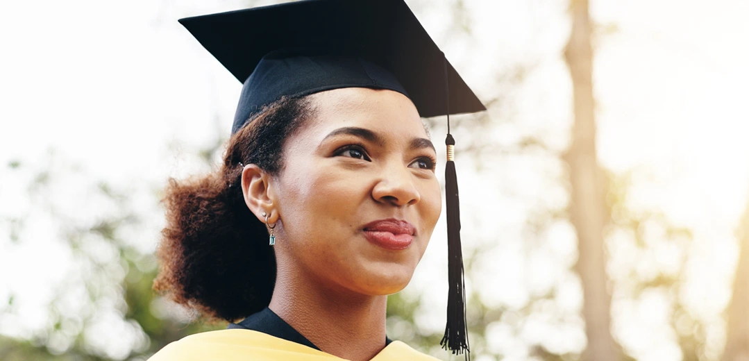 Smiling female graduate in her cap and gown