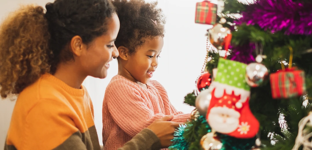 Mother and daughter decorating a Christmas tree